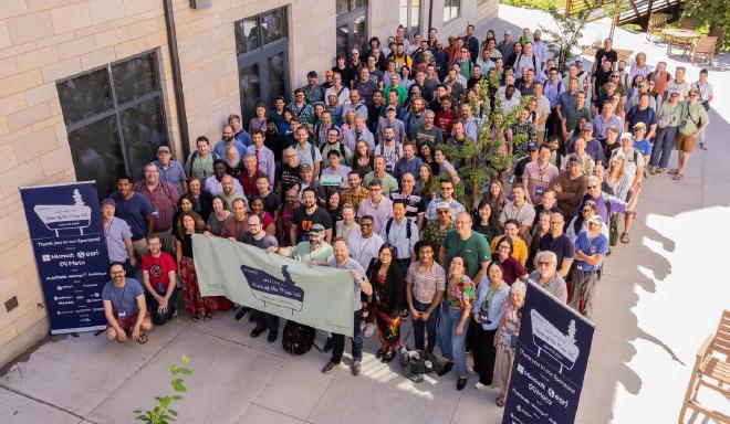 State of the Map US 2024 attendees smile for a group photo. 😊
