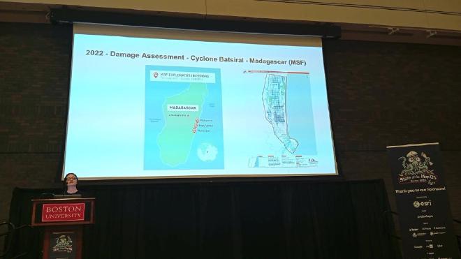 Nicole Siggins stands at a podium, presenting a past MapSwipe use case.